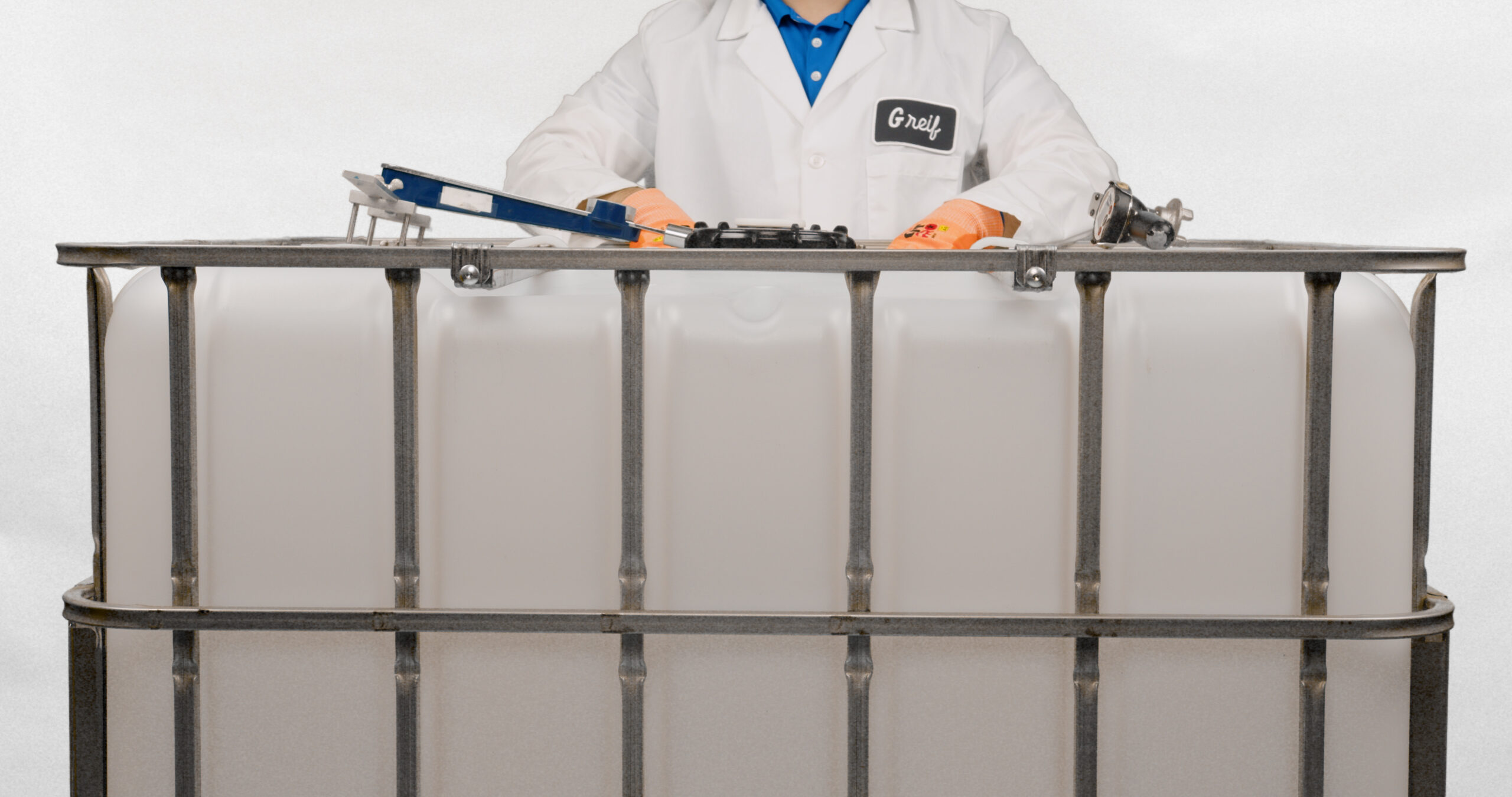 A Greif colleague stands behind a GCUBE IBC to show how to close it